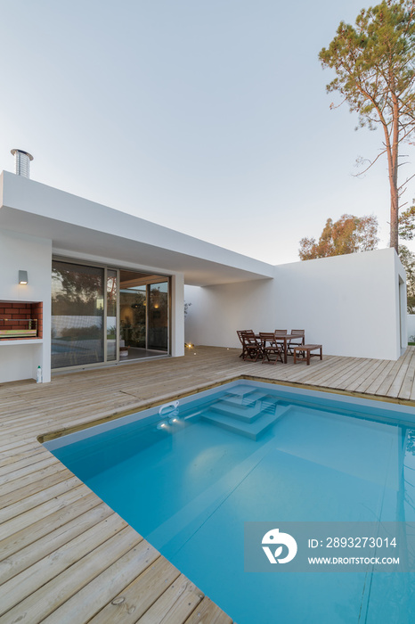 Modern house with garden swimming pool and wooden deck