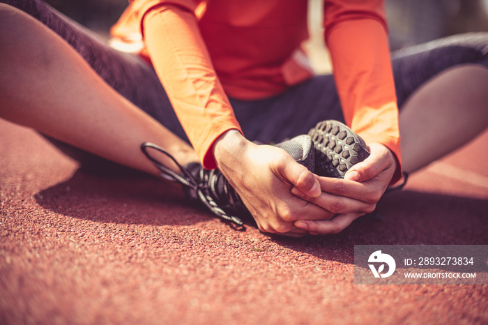 Stretching after workout. Close up image of woman legs.