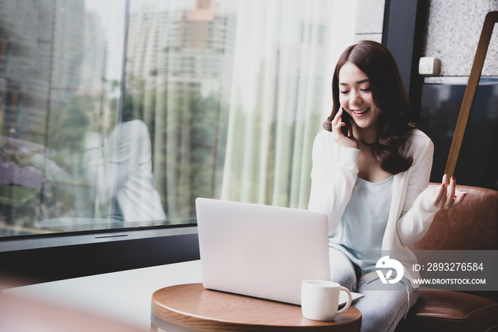 Cheerful Asian female freelancer making telephone call conversation with customer about project and 