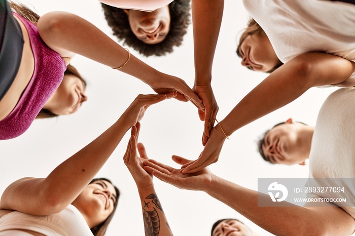 Group of young friends doing circle symbol with hands together