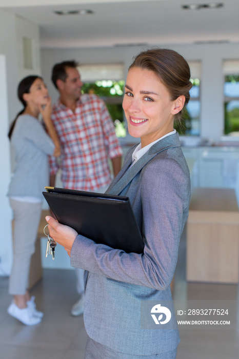 Portrait confident realtor showing house to couple