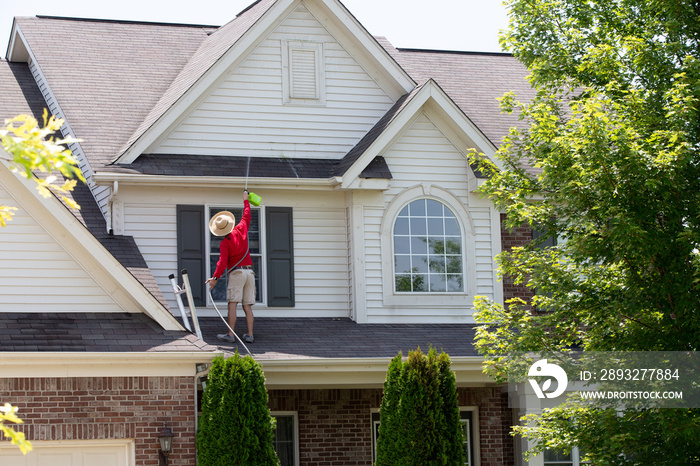 Homeowner washing the exterior of his house