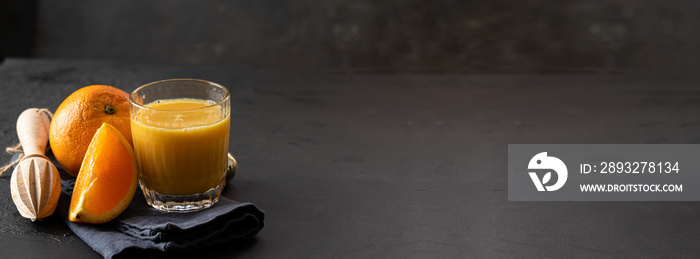 Orange juice, orange fruit  and wood citrus squeezer on dark background. Making natural juice concep