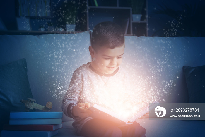 Cute little boy reading book at home