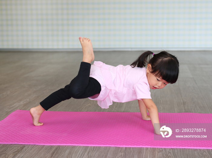 Cute toddler girl practicing yoga