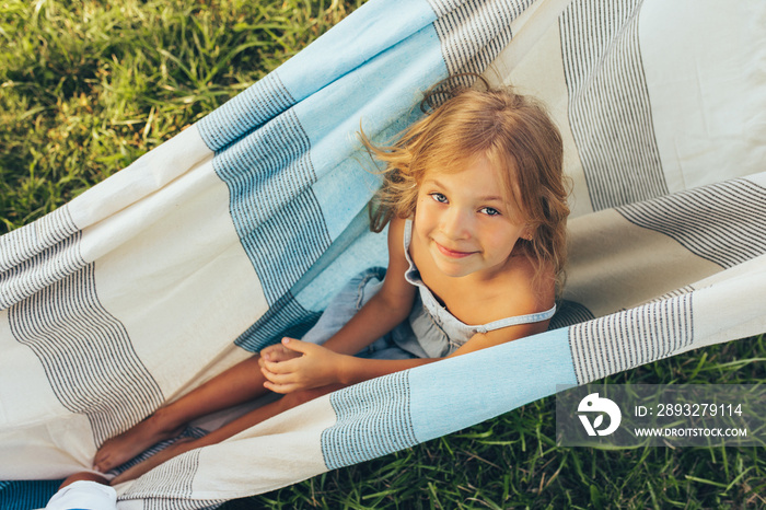 Above view image of cute little girl playing on the blanket. Happy little girl sitting on the blanke