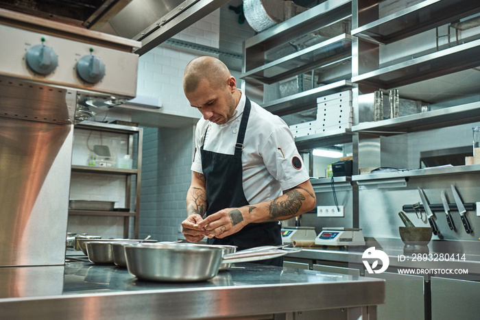 I love my work Concentrated male chef with beautiful tattoos on his arms choosing ingredients for hi