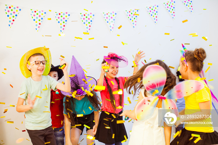 兴奋快乐的孩子们在生日派对上跳舞。孩子们正在享受闪闪发光的五彩纸屑