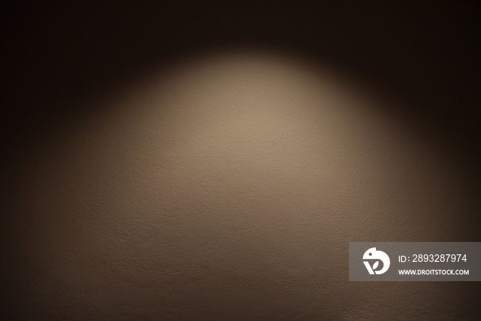 light on wall - the lamp shines with warm light on brown wall / light effect