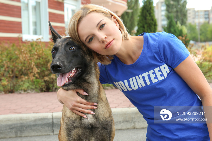 带着流浪狗在户外的年轻女性志愿者。志愿者和动物收容所的概念