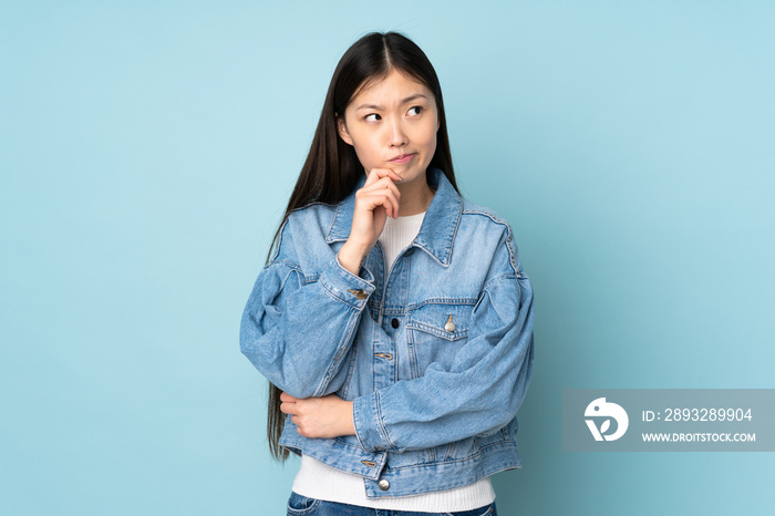 Young asian woman isolated on background having doubts and thinking