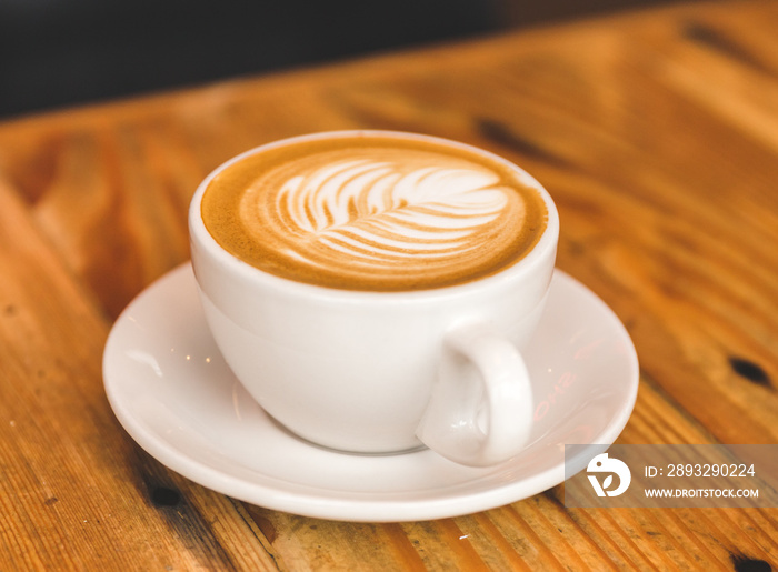 Perfect cappuccino in white cup on wood table