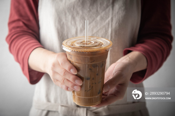 barista serving iced coffee in plastic cup