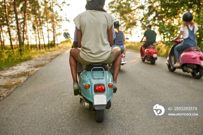 Selective focus on young multiracial people riding scooters