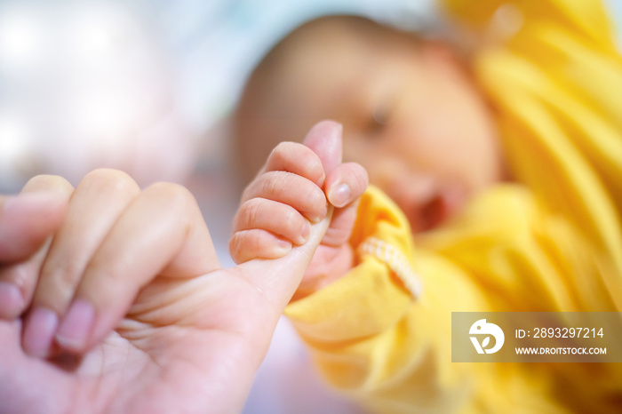 Newborn baby touching his mother hand, Baby holding finger of his mother giving senses of attachment