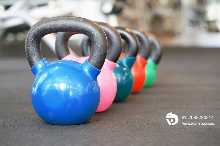 Colorful kettlebells in a row in a gym