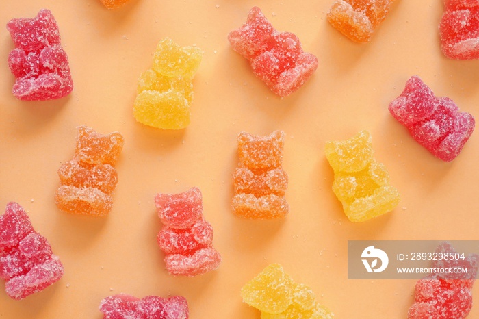 Gummy Bears Jelly Candy. Fruit Bears jelly in sugar background.Candy pattern. Orange, red and yellow