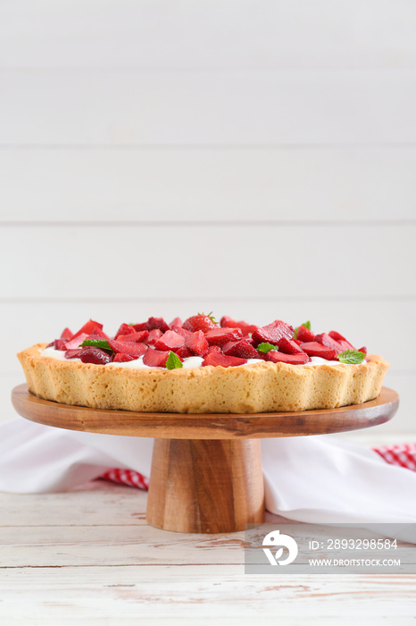 Tasty strawberry cake on white wooden table