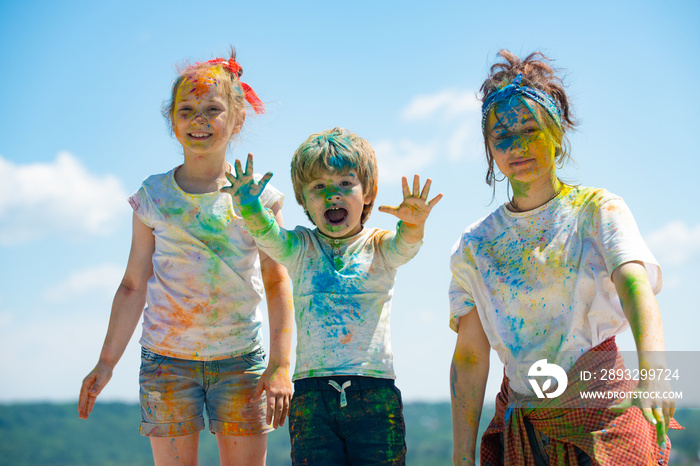 Cheerful kids showing her hands painted in bright colors. Colorful faces, color splash, coloured pow