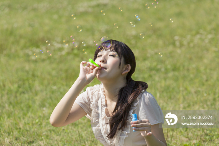 Young woman playing with bubble wand