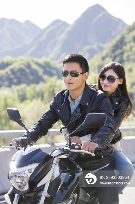 年轻情侣骑摩托车兜风