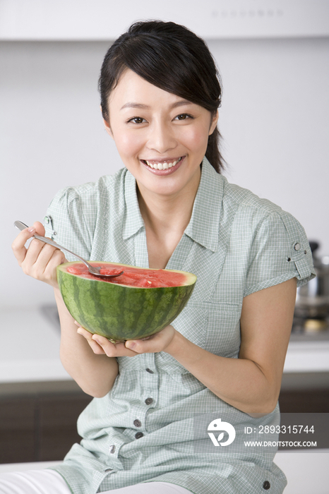 青年女子在厨房吃西瓜