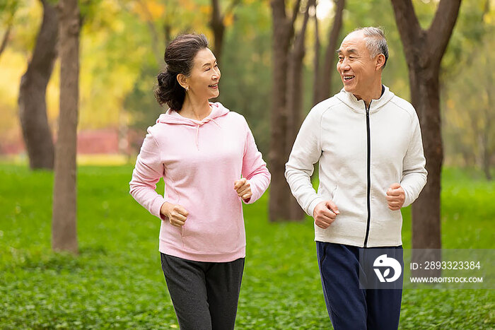 开心的老年夫妇在公园跑步