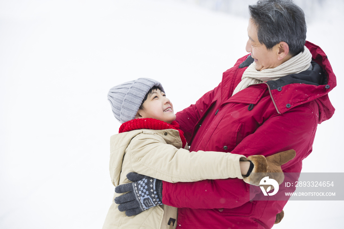 快乐的爷孙俩在雪地上拥抱