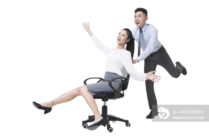 商务男士用椅子推着女同事奔跑