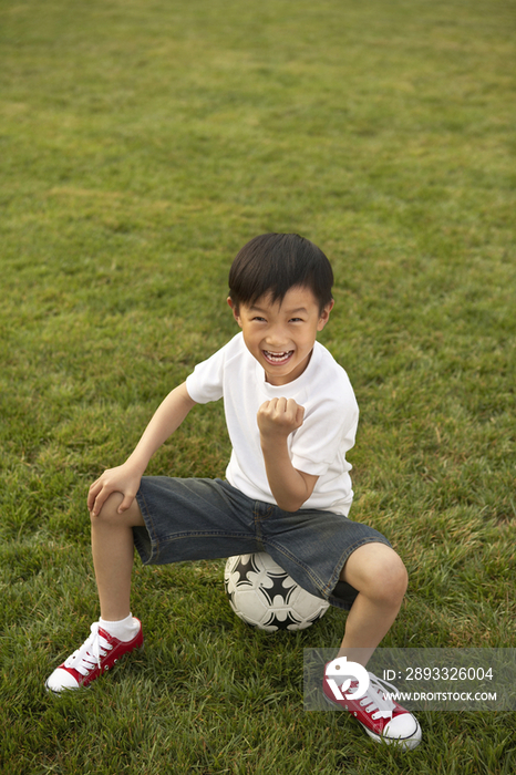 小男孩在草地上踢足球