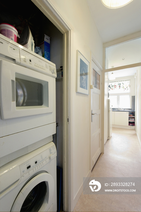 Washing machine along hallway with kitchen in the background