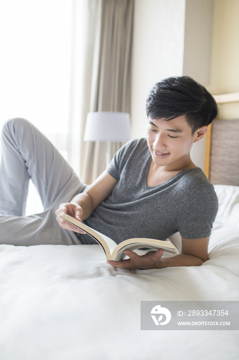 年轻男子在床上读书