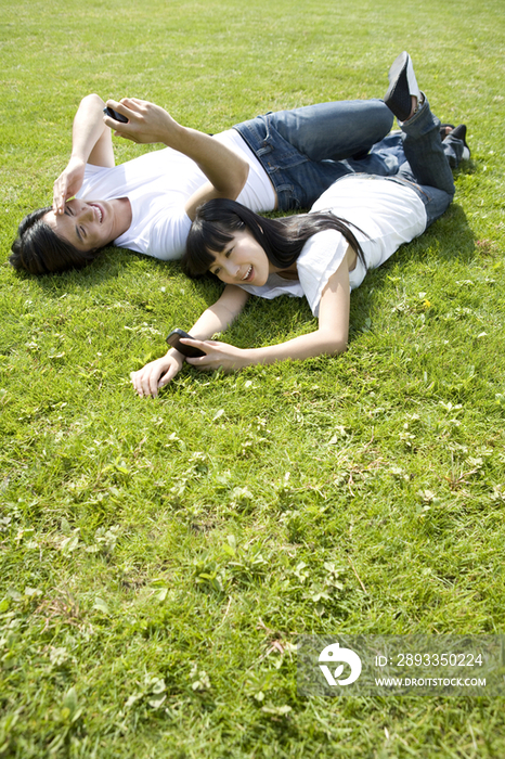 在草地上玩手机的情侣