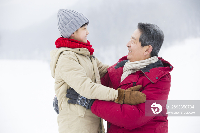 快乐的爷孙俩在雪地上拥抱