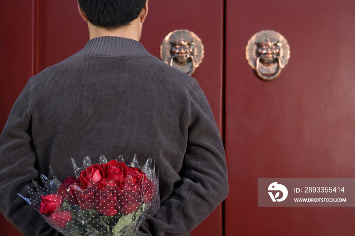 年轻男子手捧鲜花等候