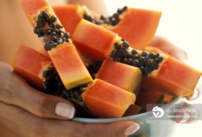 Woman holding a bowl with papaya