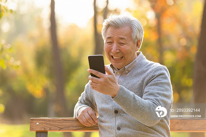 老年男子在公园使用手机