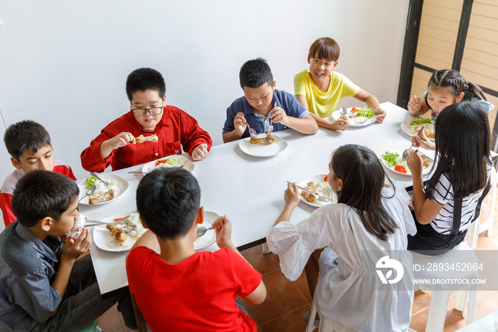 Group Of Children Eating Lunch In School