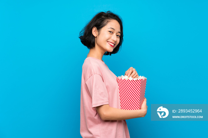 Asian young woman eating popcorns