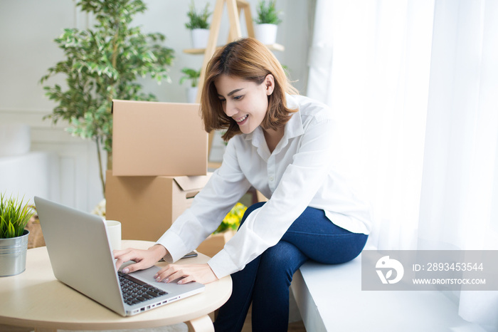 home, post, delivery and happiness concept - smiling young woman opening cardboard box at home