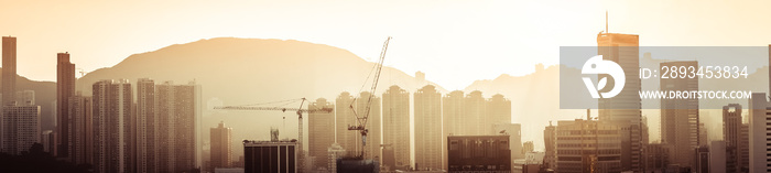 Hong Kong aerial cityscape panorama view with building construction near Victoria Harbor at sunset. 