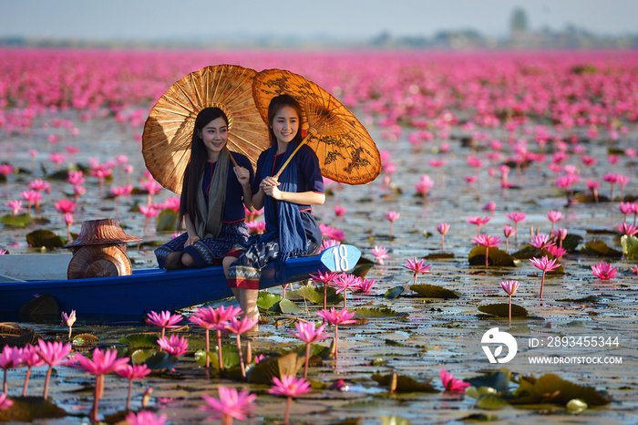 花莲湖中的老挝女人，穿着传统泰国人的女人，红莲花海乌东他尼塔