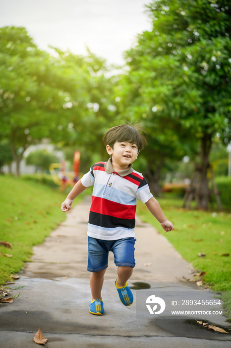 Playful Asian young boy enjoy playing at the park.