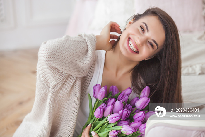 Close up portrait of young beautiful woman indoors. Attractive woman with flowers. Female with tulip