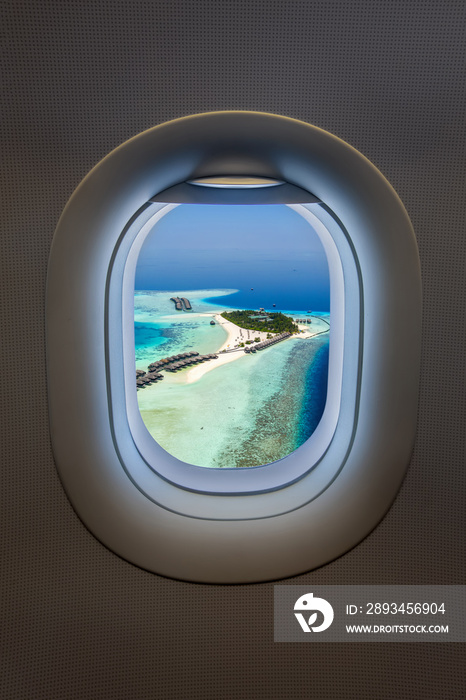 Reisenkonzept: Blick aus einem Flugzeugfenster auf eine tropische Insel auf den Malediven