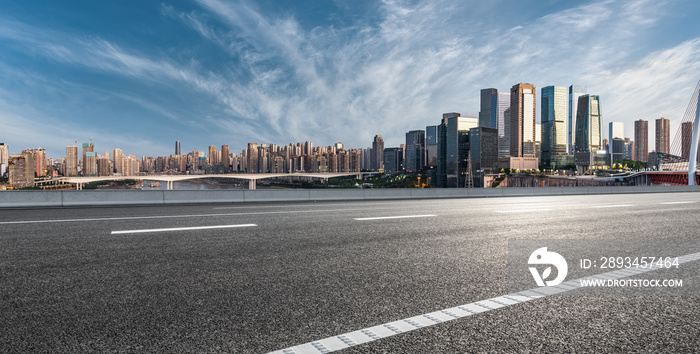 全景天际线和现代商业办公楼，道路空旷。沥青路和城市景观