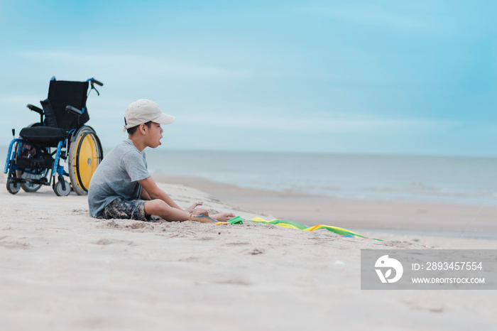 亚洲特殊儿童在海滩上快乐地玩沙子，海边的自然背景，蓝天