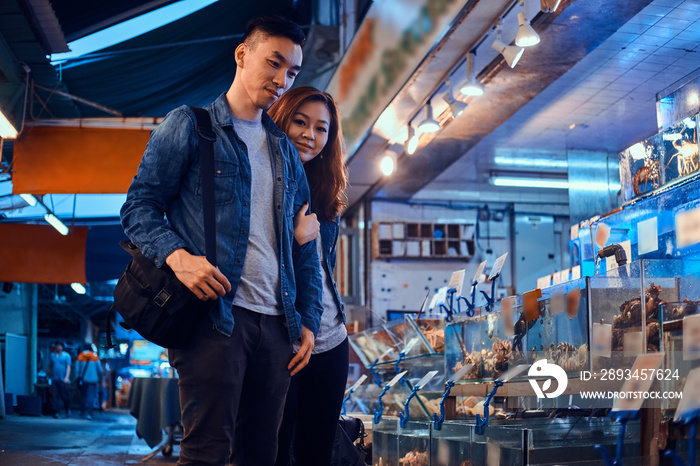 年轻的亚洲夫妇在传统的连锁市场寻找特别的东西