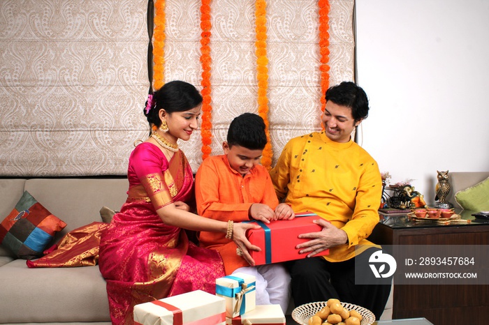 Couple giving gifts to their son on Diwali festival. 