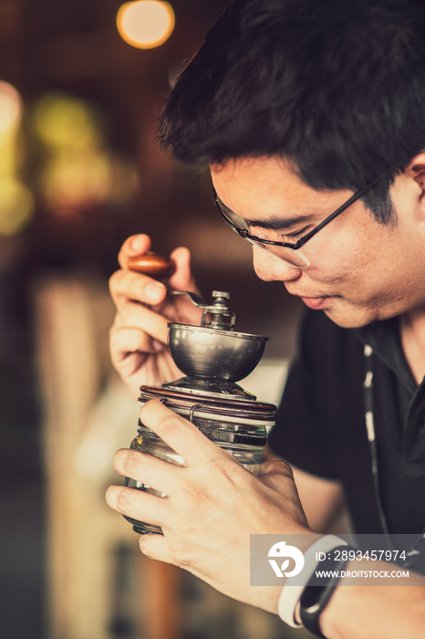 Asian men happily pouring hot coffee over a cup of coffee in the morning.